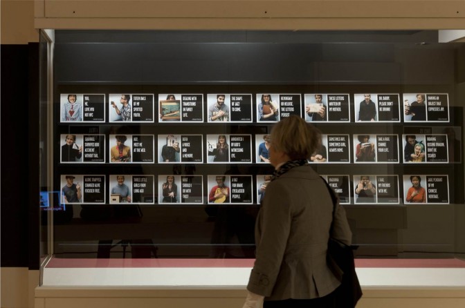 object_stories_title_cards_displayartsfwd_innovation_story A visitor in the Object Stories gallery encounters the large display depicting community members who have recorded stories about personal objects.