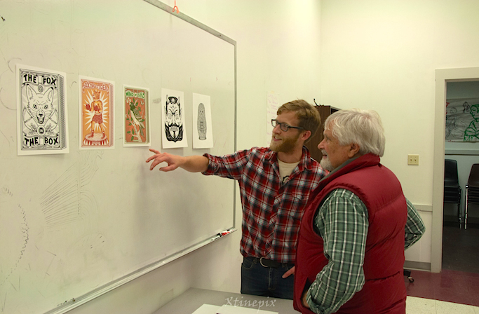Island Institute Executive Director Peter Bradley gives local artist Norman Campbell the backstory to a piece of art by visiting Sitka Fellow Bene Rohlmann. Photo by